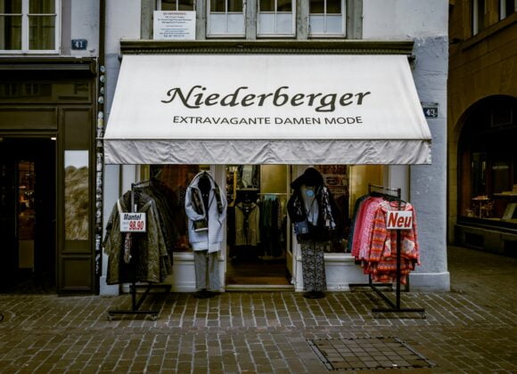Uncovering Zurich’s Fashion Scene: Supporting Local Talent and Timeless Style a store front with clothes outside