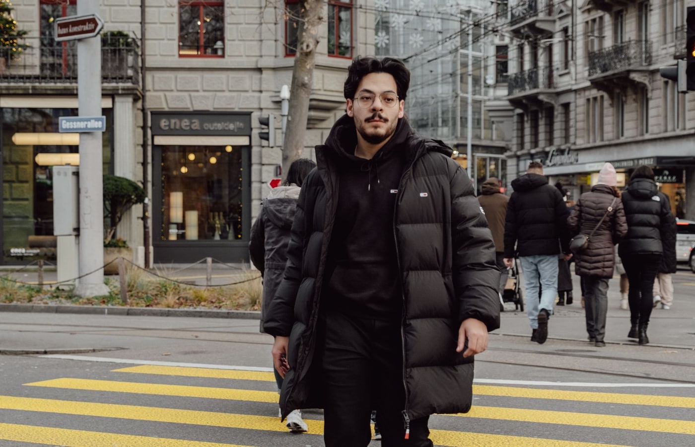 Zurich street style with black winter jacket and everyday smart casual outfit at a city crossing