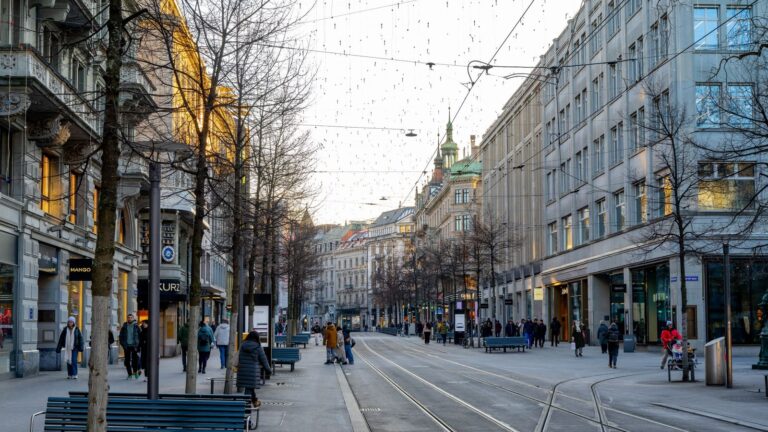 Zurich business dress code mood on Bahnhofstrasse with tram tracks and polished finance district buildings