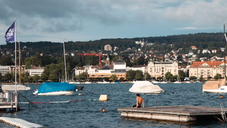 Zurich summer outfit mood with Lake Zurich swimmers boats and city shoreline in warm weather
