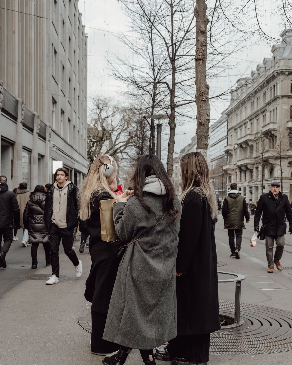 Zurich winter coat outfits with grey wool coat black coat and winter boots on a city street