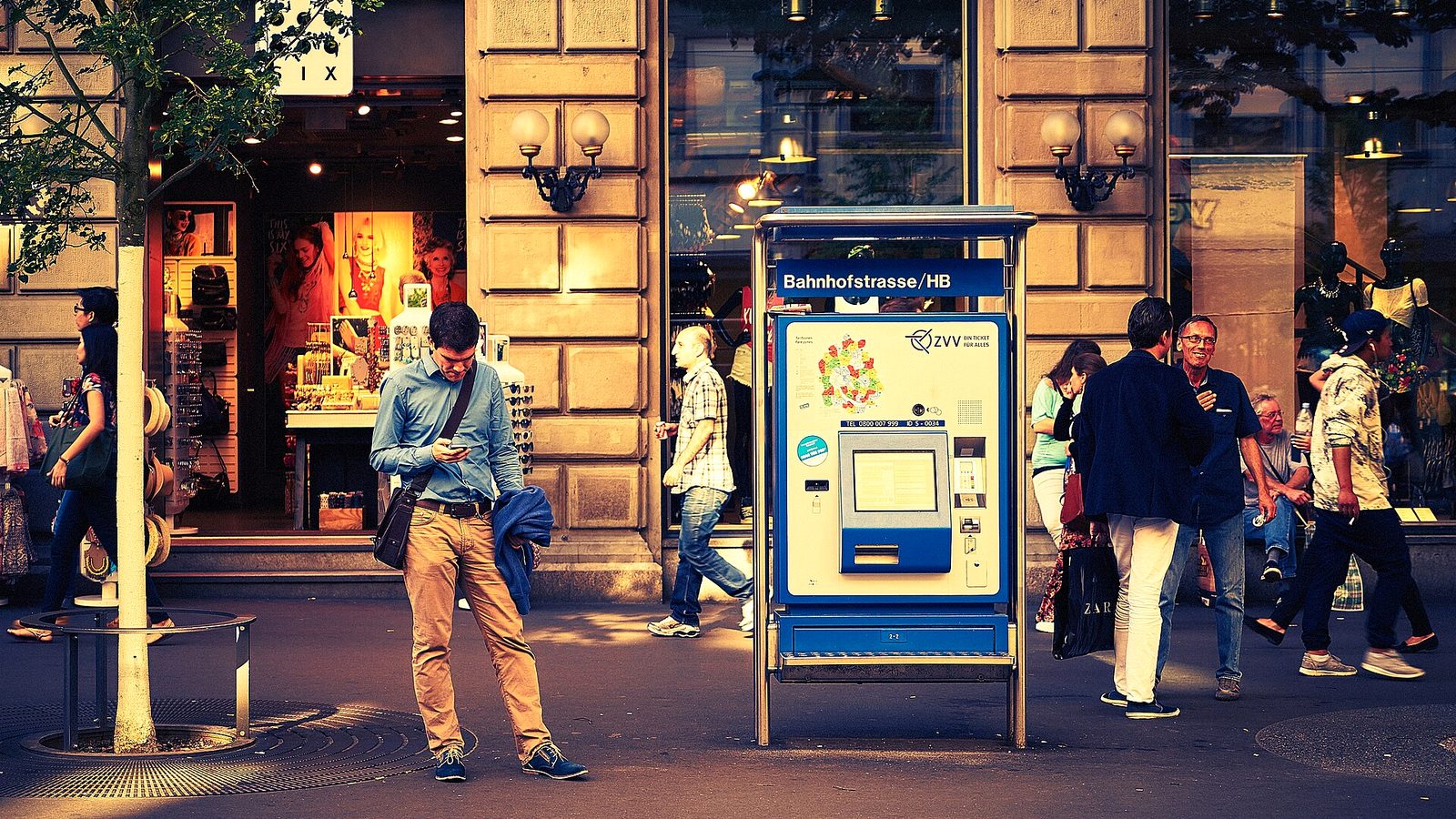 Bahnhofstrasse street style scene with pedestrians and trams at a Zurich tram stop