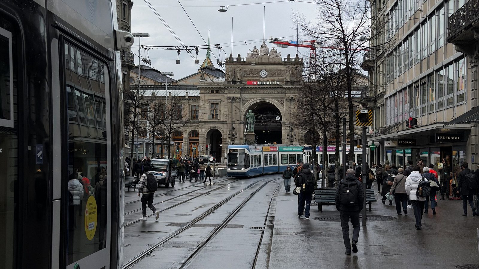 Crowd of shoppers and commuters walking Bahnhofstrasse near Zurich main station between trams