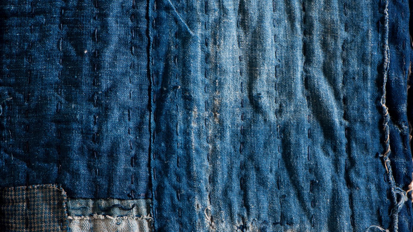 Japanese boro textile in deep indigo with visible sashiko mending stitches